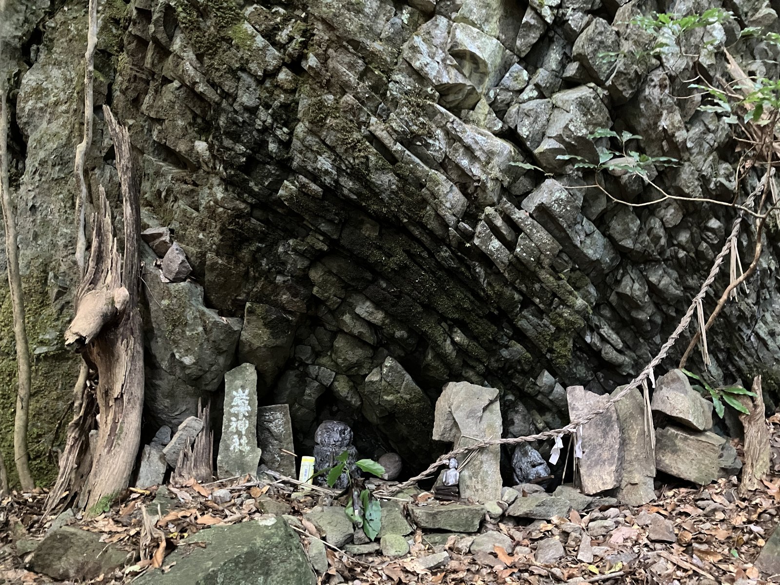 岩壁の下に小さな祠が並ぶ神社